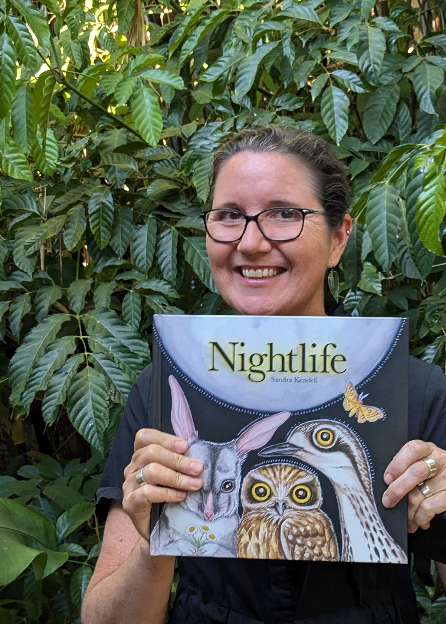 Author Sandra Kendell holding her book Nightlife 