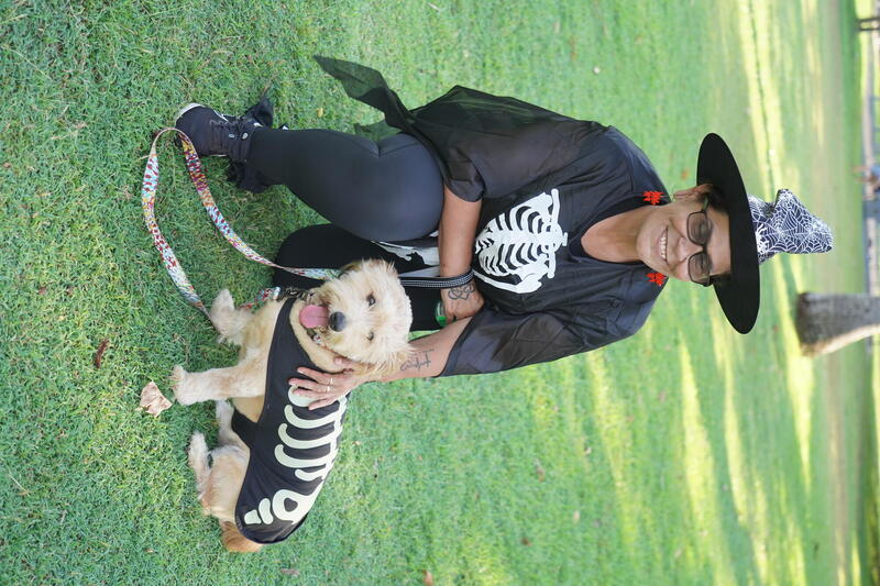 Dog and pet parent dressed as skeletons