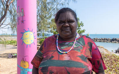 Artist Tara Darcy standing next to her Light pole artwork 