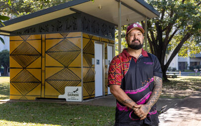 Artist Trent standing next to his artwork