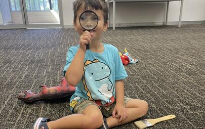 young person looking through a magnifying glass