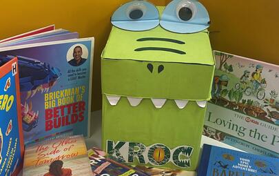 croc made from a cardboard box surrounded by books