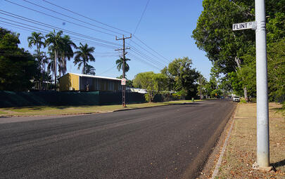 Road pavement between grass and powerlines