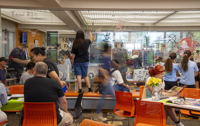Young people take over the library at Geektacular, covering a whole glass wall with art made from chalk pens