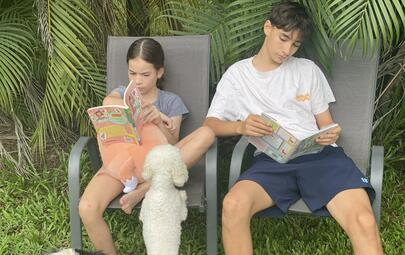 Two children reading outside for the Dalay Reading Club in Darwin.