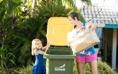 Lady and kid putting recycling in bin