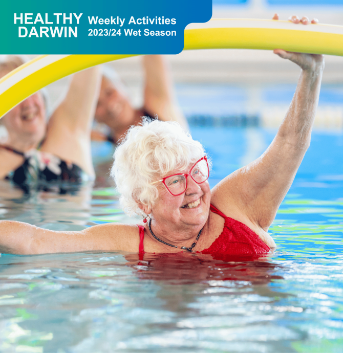 Elderly lady working out in the pool with a pool noodle, while smiling