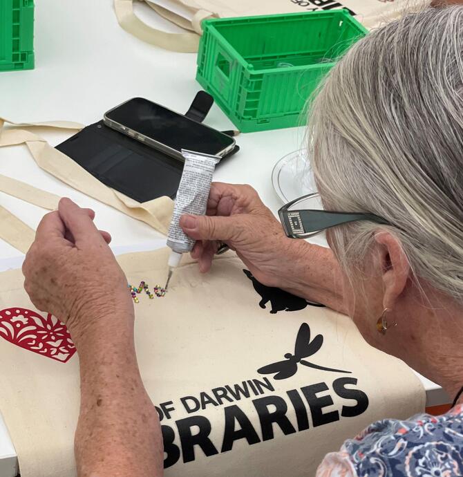 someone decorating a library bag