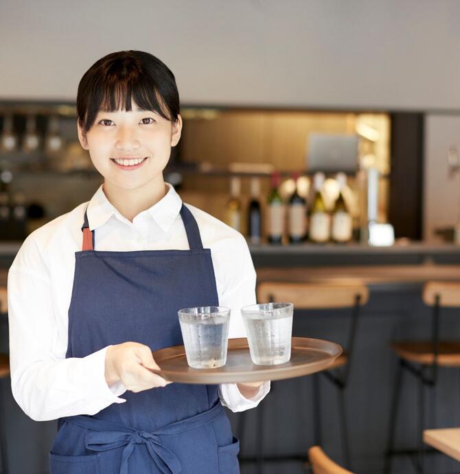 Young person serving water on a tray