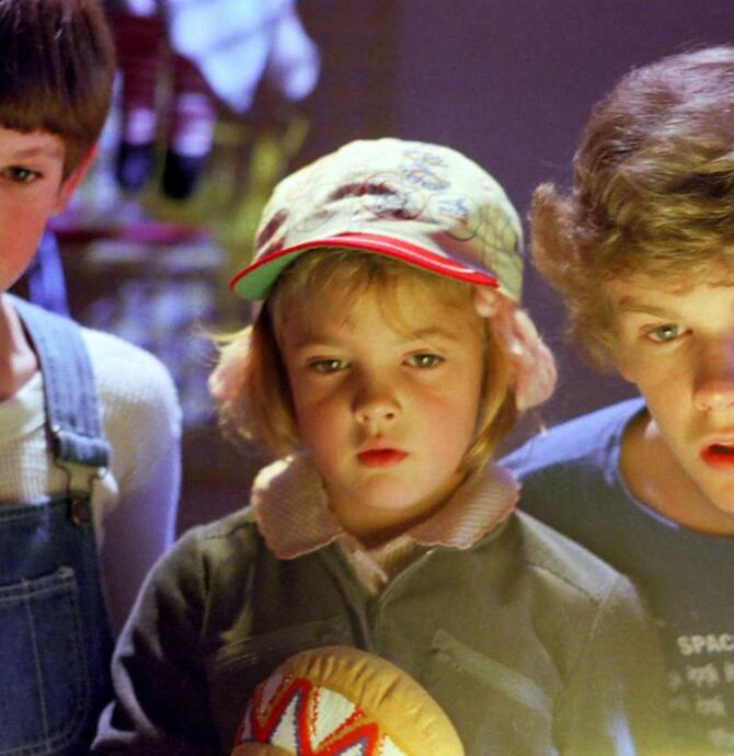 three children looking at an unseen glowing object. 