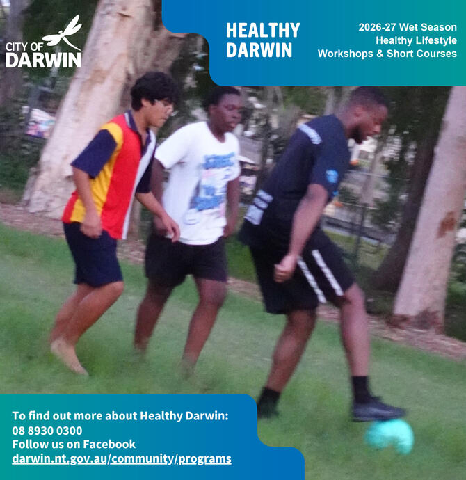 Three young adults playing soccer in a park