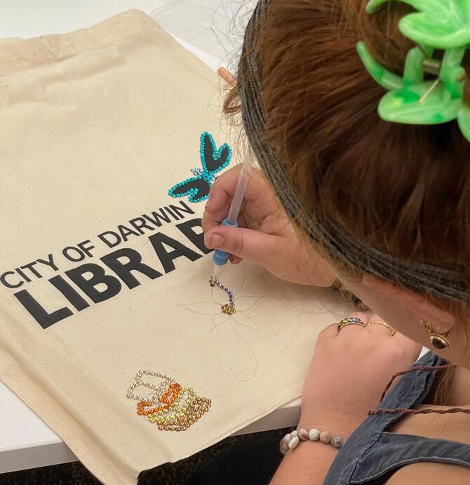 image of young person decorating a library bag