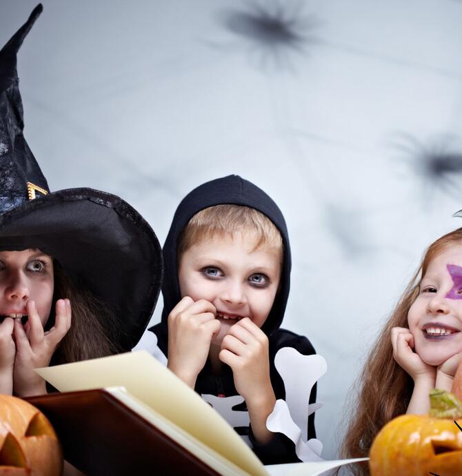Halloween Kids Reading surrounded by pumpkins