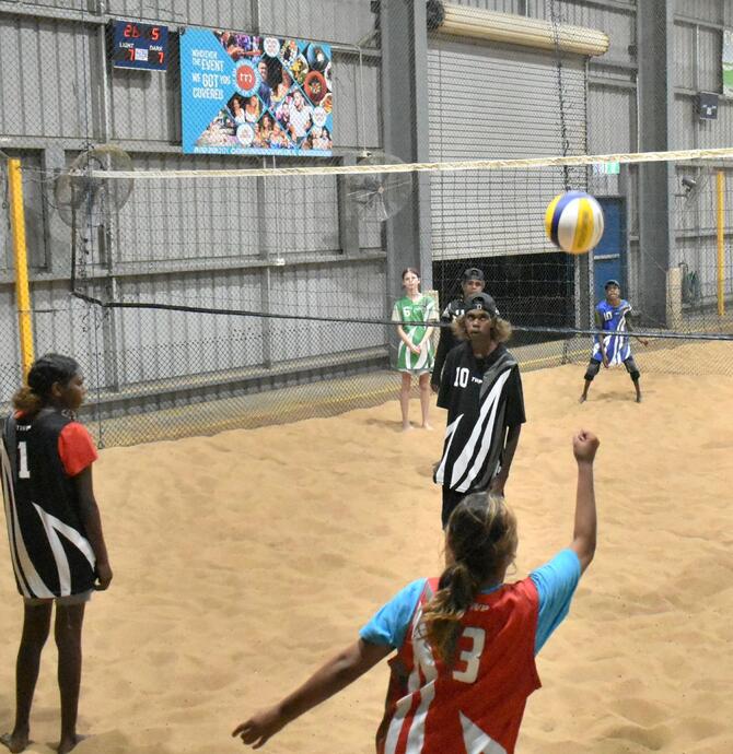 young people playing indoor beach volleyball