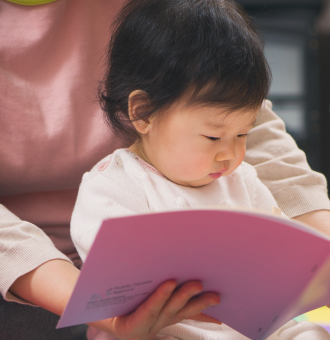 toddler looking at a book