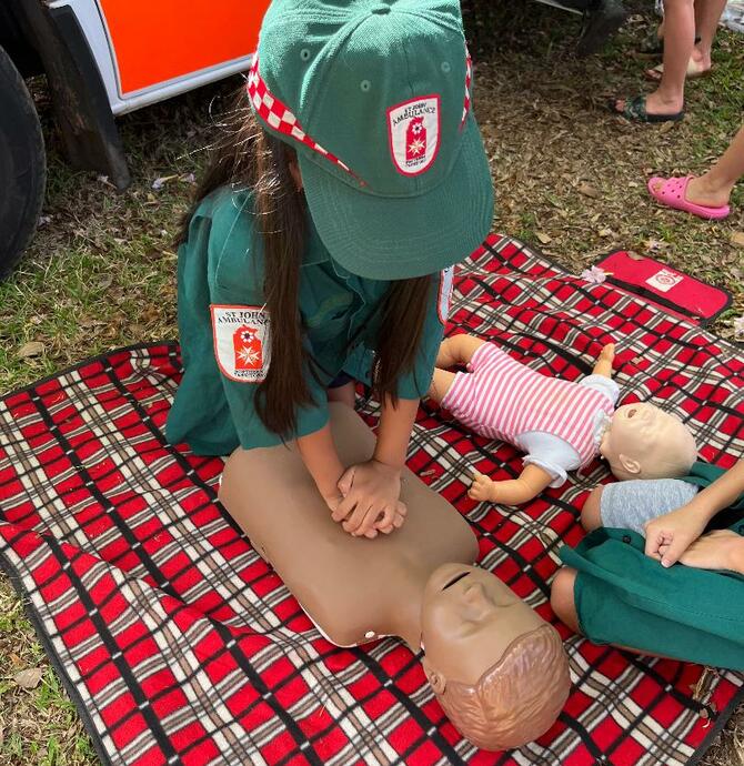 image of a child with a first aid dummy manequin