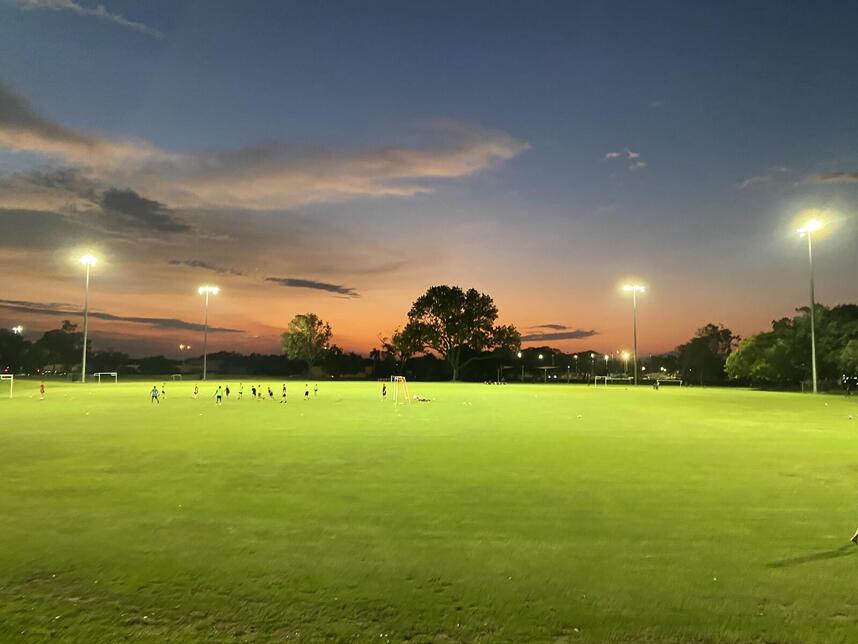 Bagot Oval at sunset with sports field lighting illuminated