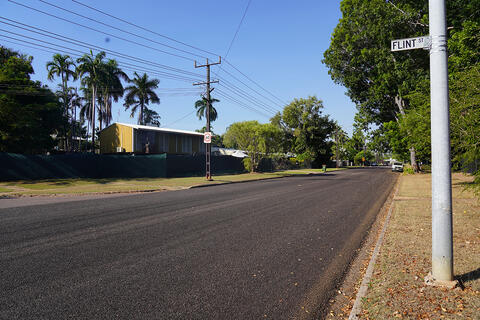 Road pavement between grass and powerlines