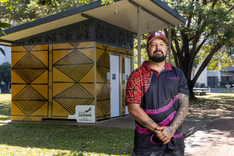 Artist Trent standing next to his art