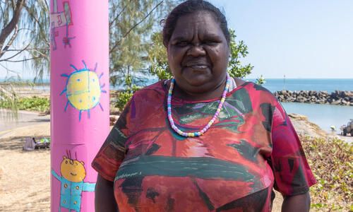 Artist Tara Darcy standing next to her Light pole artwork 