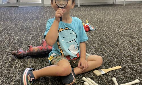 young person looking through a magnifying glass