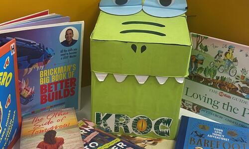 croc made from a cardboard box surrounded by books