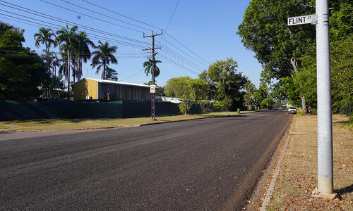 Road pavement between grass and powerlines