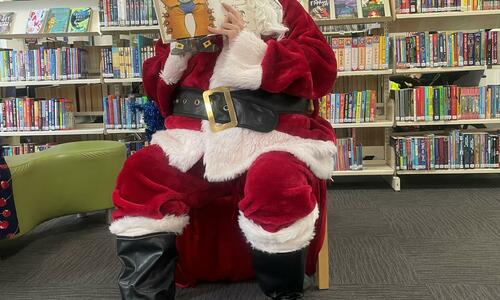 image of Santa reading a book for story time